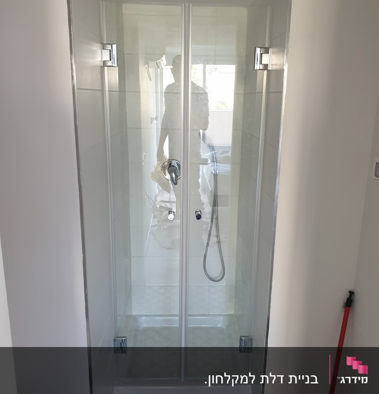 מקלחון עם דלתות זכוכית וברז מקלחת